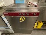 stainless steel dishwasher in a commercial kitchen with dirty flooring