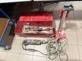 a red tool box sitting on the floor next to a table