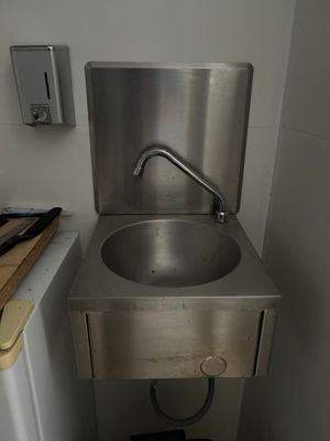 a sink in the corner of a small bathroom