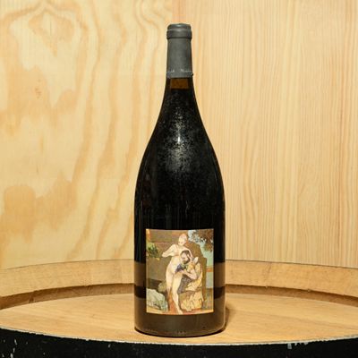 a bottle of wine sitting on top of a barrel