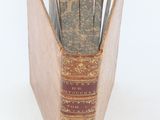 an old book that is open on a white surface
