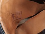 the bottom of a pair of black leather shoes with a brown sole