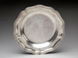silver plate with scalloped edge on a plain surface