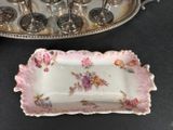 a silver tray with a pink and white plate on it and a silver tray with a pink and white plate on it