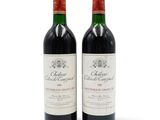 deux bouteilles de vin rouge posées l'une à côté de l'autre sur une surface blanche