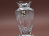 un petit vase en verre muni d'une étiquette, posé sur une table