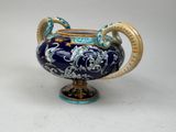 an image of a blue and gold vase on a white surface