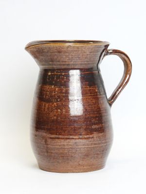 a brown pitcher with a handle on a white background
