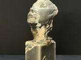an image of a sculpture of a head on top of a block