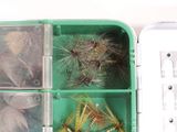 a green box filled with different types of fishing lures
