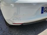 a close up of a white car with a license plate on it