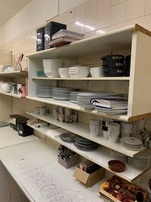 une cuisine où il y a beaucoup de vaisselle et de plats sur les étagères