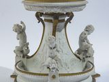 un socle blanc et doré surmonté de statues
