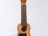 a guitar hanging from a string on a white wall