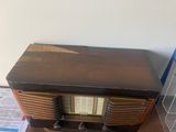 an old radio sitting on a table next to a wall