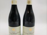 deux bouteilles de vin rouge posées l'une à côté de l'autre sur une surface blanche