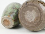 two vases sitting next to each other on a white surface