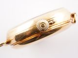 an image of a close up of a gold bracelet on a white surface