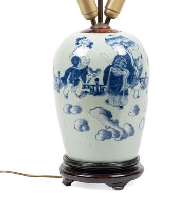 un vase bleu et blanc sur lequel sont posées deux lampes