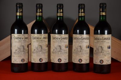 four bottles of wine are lined up on a table