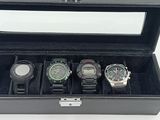 four watches in a black case on a white table