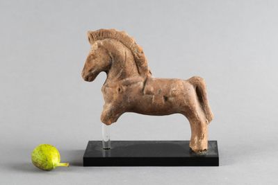statue d'un cheval posée sur un socle, à côté d'une pomme verte