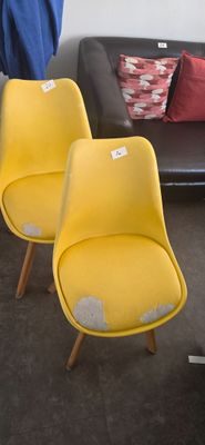 deux fauteuils jaunes placés l'un à côté de l'autre dans un salon