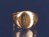 a close up of a gold signet ring on a blue surface