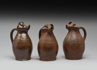 trois vases marron posés les uns à côté des autres sur une table
