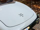 a close up of a white car parked on the side of the road