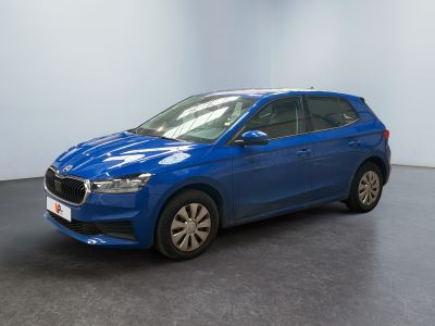 une voiture bleue garée dans une pièce aux murs blancs