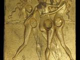 gold plaque depicting three women in bathing suits on a beach