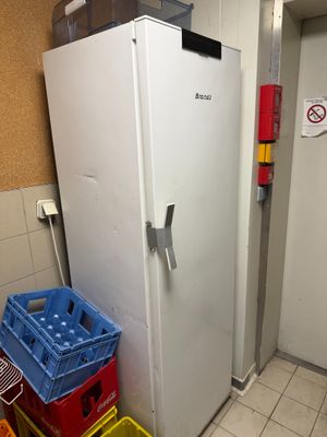 a white refrigerator in the corner of a room next to a wall