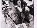 black and white photograph of a man sitting in front of a painting