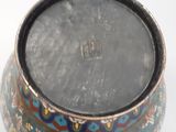 a small bowl with a design on it on a white surface