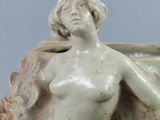 a statue of a woman sitting on a vase