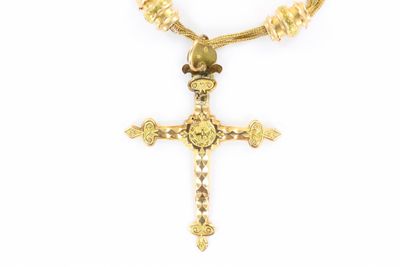 un gros plan d'un collier orné d'une croix sur fond blanc