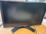 a close up of a computer monitor on a wooden desk