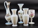 five vases and a goblet sitting on a table