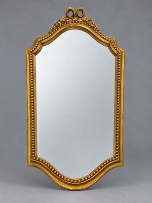 un miroir à cadre doré orné d'un motif décoratif sur le pourtour