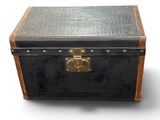 une vieille valise noire munie d'une serrure en laiton