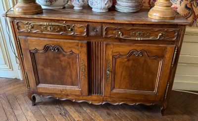une armoire en bois sur laquelle sont posées de nombreuses assiettes
