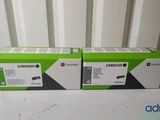 two boxes of black and green toner cartridges sitting on a table
