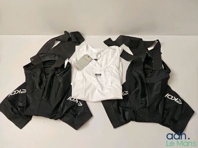 trois paires de vêtements noirs et blancs posées sur une surface blanche