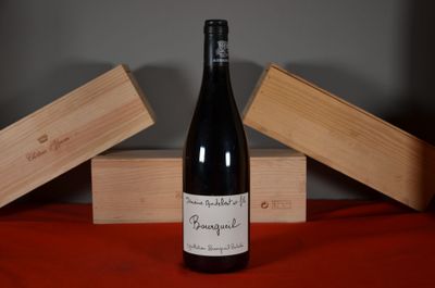 a bottle of wine sitting on a table next to two wooden boxes