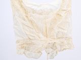 an image of a white top hanging on a black hanger