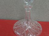 a glass vase with a flower on it on a red surface