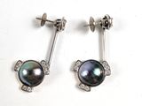 une paire de boucles d'oreilles en perles noires et diamants sur fond blanc