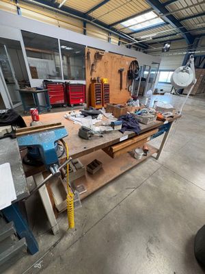 a workbench in the middle of a room with many tools on it