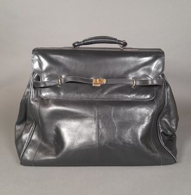 black leather backpack with gold buckles on the front